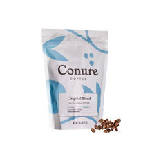 Load image into Gallery viewer, Conure Coffee Original Blend bag displayed on a clean, light background alongside a ceramic cup of black coffee. Modern, minimalist design with soft blue tones reflects the smooth, balanced flavour of this small-batch roasted Australian coffee.