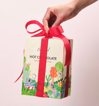 Load image into Gallery viewer, Nomad Drinking Chocolate Gift Box with red ribbon hand held .