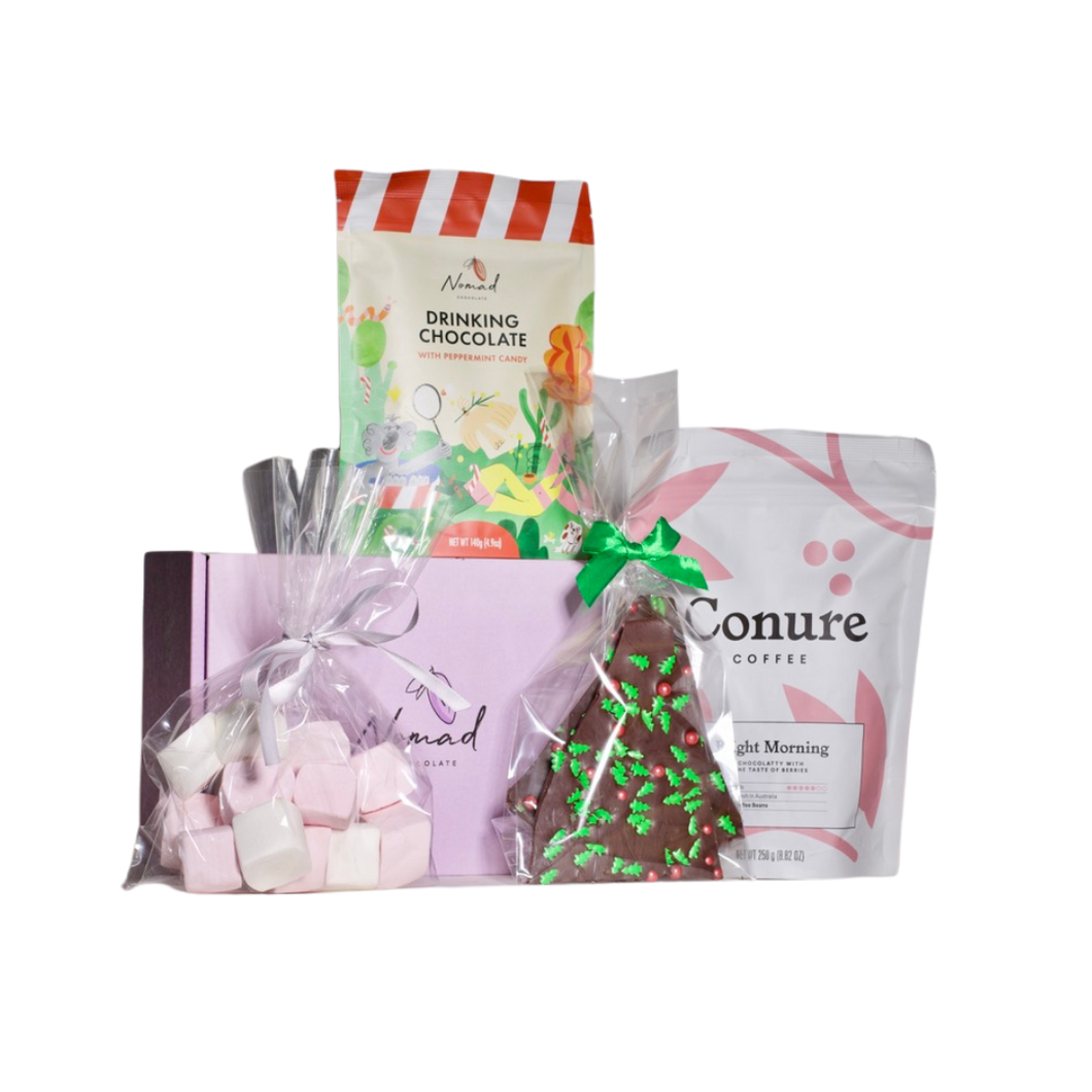 Image of Nomad Chocolate gift box in purple, Nomad Hot chocolate peppermint candy 140g in a pouch bag, Conure Coffee bright morning coffee beans in 250g bag, cellophane bag with pink and white big marshmallows and Nomad Chocolate bark packed in cellophane bag with Christmas toppings in a shape of green Christmas tree and red balls