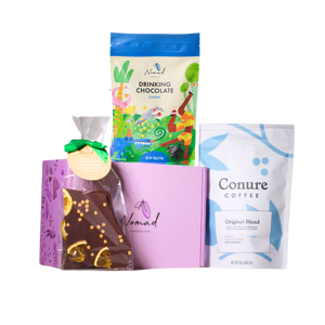 Image of conure coffee beans 250g, Nomad chocolate bark with orange and white pearls, nomad gift box in purple colour and Nomad hot chocolate classic in a pouch bag 140g designed by Elin Matilda