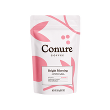 Load image into Gallery viewer, Conure Coffee Bright Morning chocolate with the taste of berries, in a white stand-up pouch with pink leaf and berry graphics.