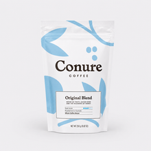 Load image into Gallery viewer, A stand-up pouch of Conure Coffee Original Blend on a clean white background. The packaging is white with light blue abstract leaf-like shapes and black text reading 'Conure COFFEE' and 'Original Blend'.