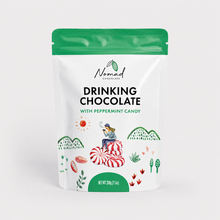 Load image into Gallery viewer, A stand-up pouch of Nomad Chocolate Drinking Chocolate with Peppermint Candy, featuring a white bag with a green top seal and colorful candy-themed illustrations on a light gray background.