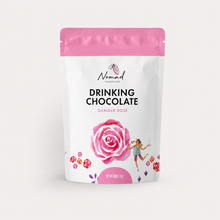 Load image into Gallery viewer, A stand-up pouch of Nomad Chocolate Drinking Chocolate in Damask Rose flavor, featuring a white package with a pink top band, a large pink rose illustration, and a small whimsical girl drawing character.