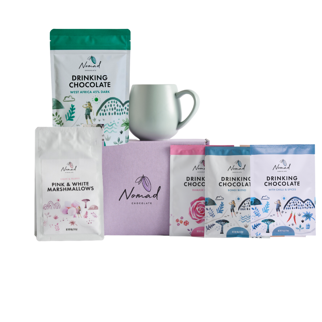 Nomad chocolate gift in purple box with Three packets of Nomad drinking chocolate 40g and one packet of Nomad drinking chocolate westa frica 200g, pink and white marshmallows 40g and robert gordon mug in eucalyptus colour  
