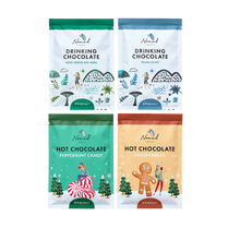 Load image into Gallery viewer, Four stand-up pouches of Nomad hot chocolate  arranged in a 2x2 grid on a plain white background. The top two are Drinking Chocolate bags with illustrated winter scenes in green and blue; the bottom two are Hot Chocolate bags with illustrated holiday scenes in teal and beige. West Africa 45% Dark drinking chocolate, bondi blend drinking chocolate 40g, hot chocolate peppermint candy 40g and hot chocolate gingerbread 40g