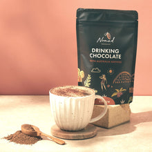 Load image into Gallery viewer, Nomad drinking chocolate with Australian  natives 200g bag with image of hot chocolate and cacao powder